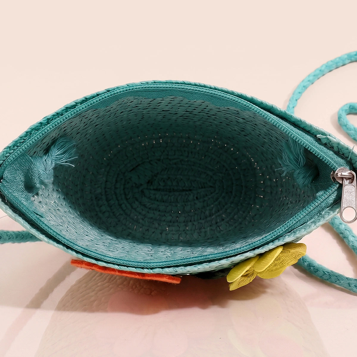 Girls green woven sling bag featuring yellow and orange floral applique